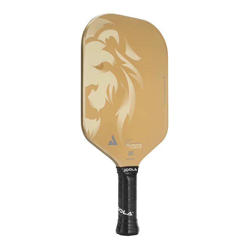 The Pickleball Zone TYSON MCGUFFIN MAGNUS CAS 14MM Pickleball Paddle features a golden face decorated with a lion's visage, taking inspiration from Tyson McGuffin. Its handle, wrapped in black grip tape and emblazoned with the "Pickleball Zone" logo in white letters, enhances the paddle’s sleek and contemporary design.