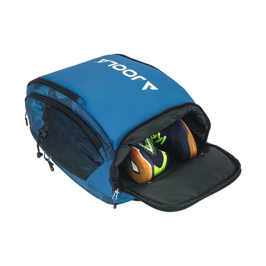 A blue Pickleball Zone JOOLA Vision II Deluxe Pickleball Backpack partially unzipped, revealing a pair of green and black sports shoes inside. Perfect for on-the-go players, the bag has mesh pockets on the side and appears spacious and functional, offering ultimate storage.