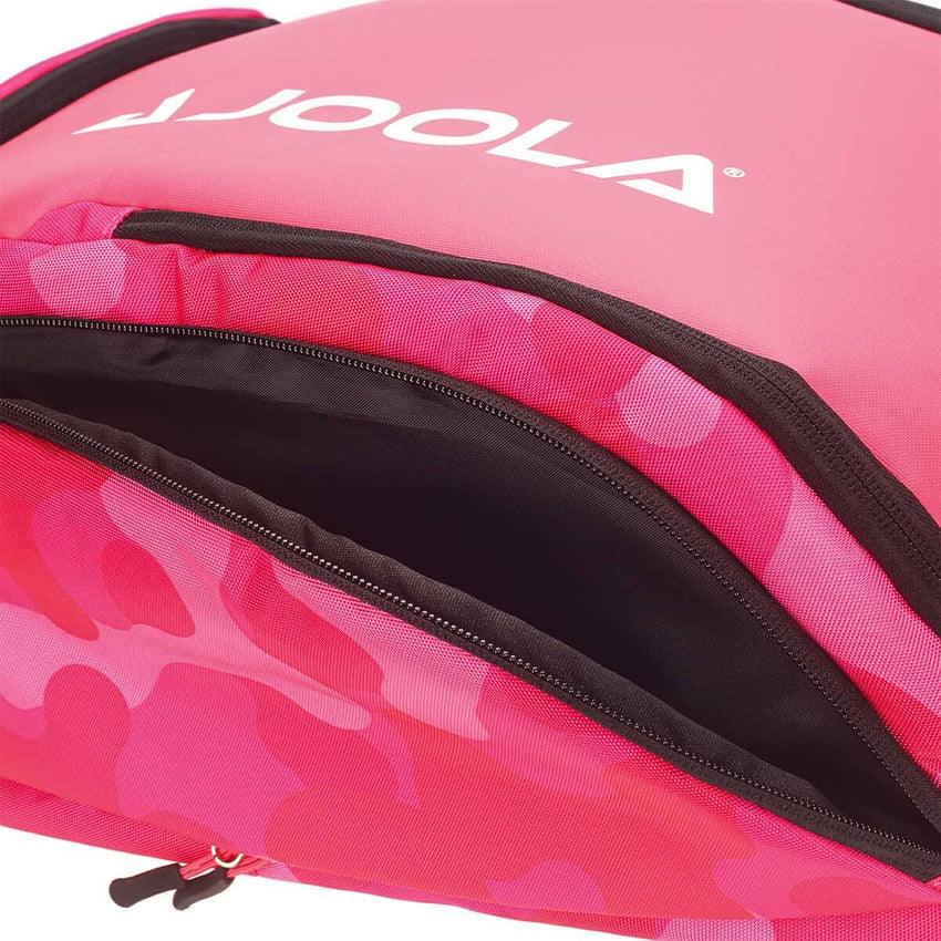 Close-up of a pink and red Pickleball Zone JOOLA Vision II Deluxe Pickleball Backpack with a partially open zipper revealing a pocket. The bag features a bold white "JOOLA" logo on the top. Designed for on-the-go players, it offers ultimate storage with its mix of solid colors and camouflage patterns.